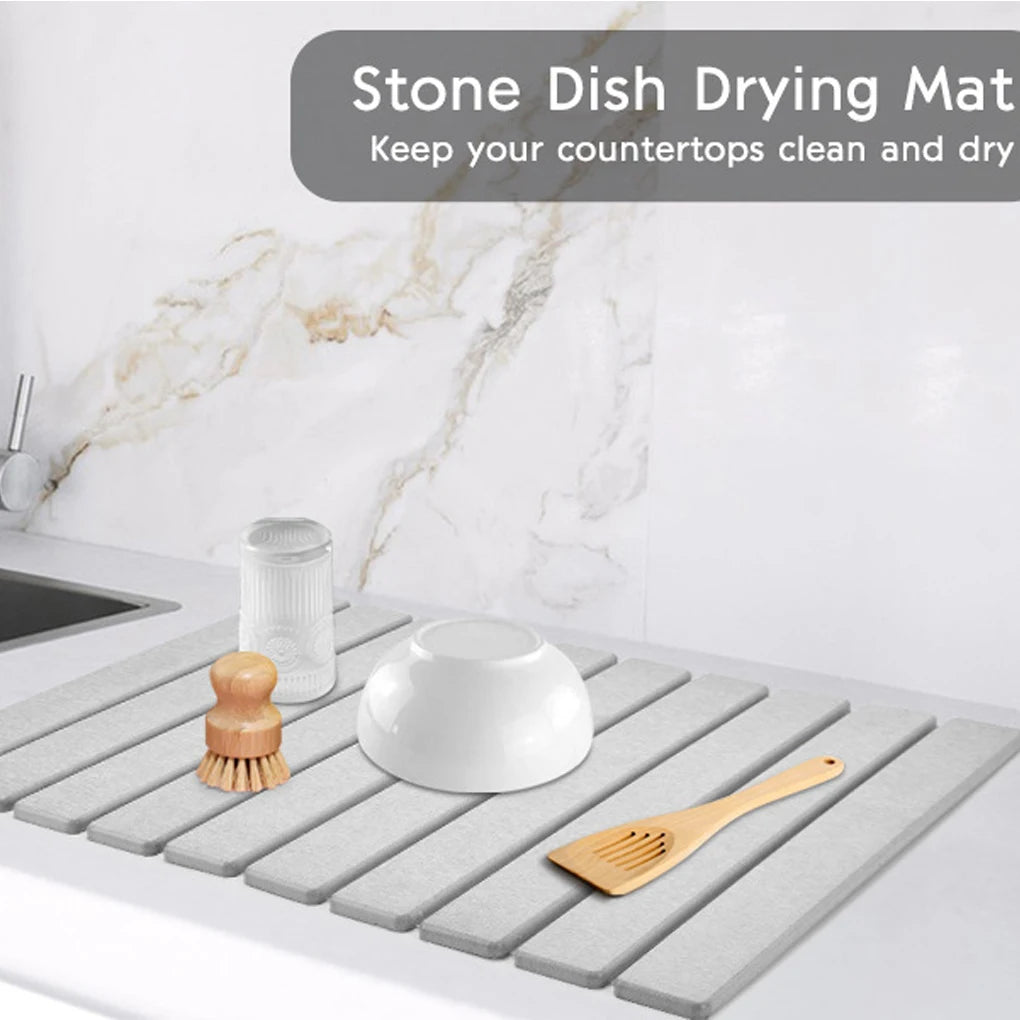 Stone dish drying mat on countertop with dishes and utensils