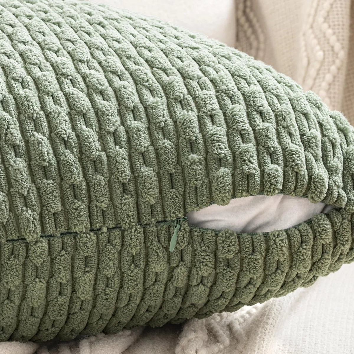 Close-up of green textured corduroy pillow cover with zipper detail