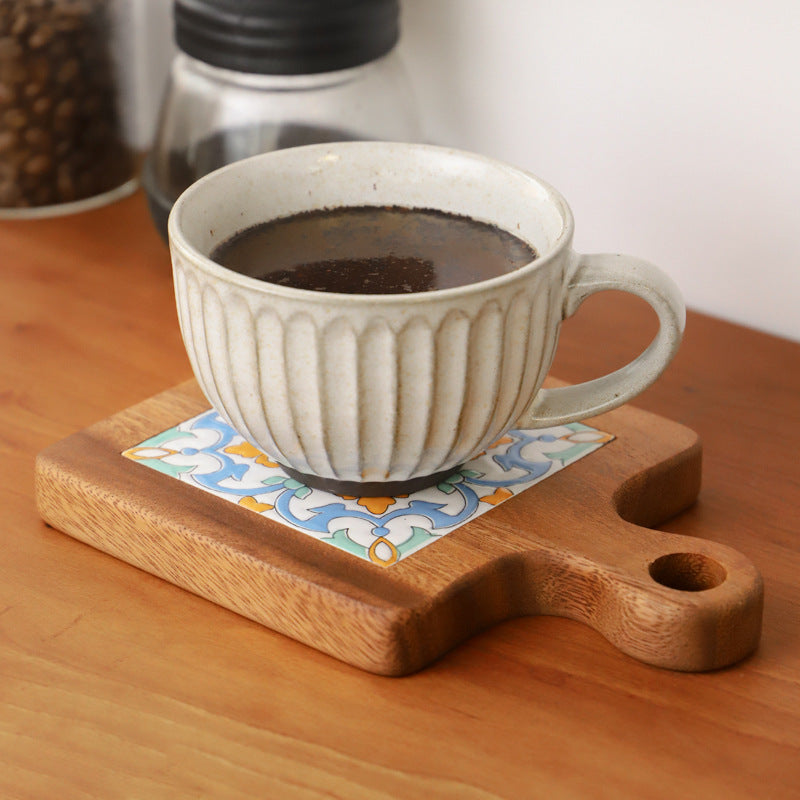 Ceramic cup placed on decorative wood and ceramic table mat